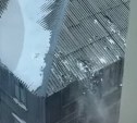 При расчистке крыши многоэтажки в Южно-Сахалинске повредили малоэтажный старенький дом